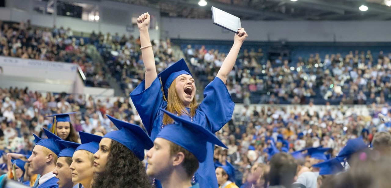 An Academy District 20 graduate cheers during a graduation ceremony.